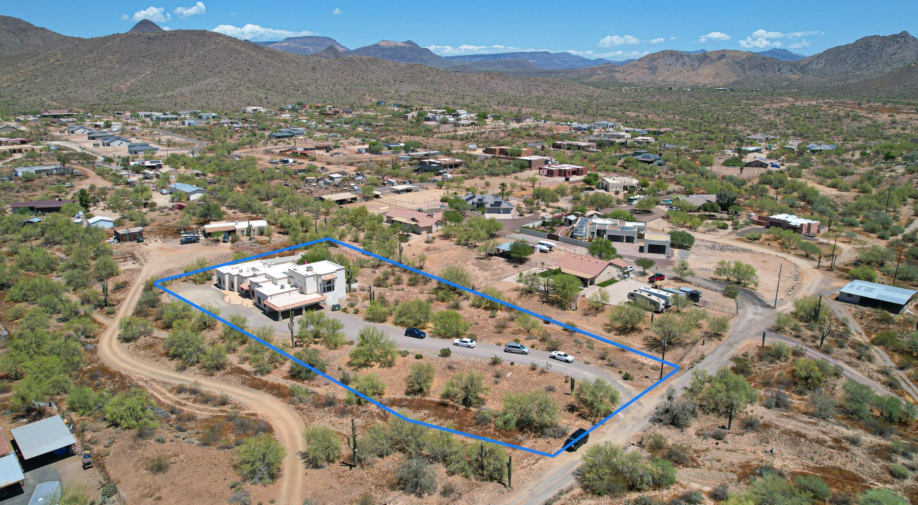 Aerial view of the two-acre property outlined against the surrounding hills